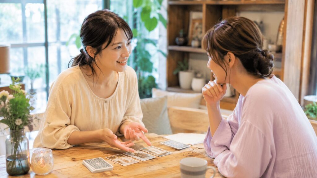 タロットカードを囲んで占いについて楽しそうに話す日本人女性二人